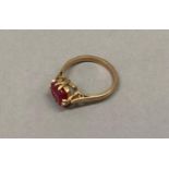 A George V dress ring in 9ct gold claw set with a cushion shaped faceted synthetic ruby, approximate