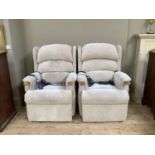 A pair of electrically operated reclining armchairs upholstered in oatmeal velour