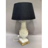 A 1960's/70's creamware table lamp of plant form on a gilt base with a black and a cream shade,