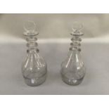 A pair of late Georgian triple neck decanters with disc stoppers, the bodies etched with panels of