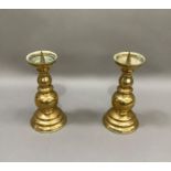 A pair of brass pricket candlesticks with baluster columns and on stepped circular bases