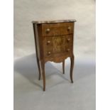 A continental bedside cabinet of serpentine outline having three drawers and painted with