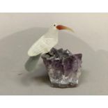 A Brazilian carved mineral specimen figure of a long beaked bird resting on a rock, 9cm high