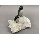 A Brazilian carved mineral specimen group of two penguins perched on an icy rock, 20cm by 24cm