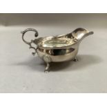 A Victorian silver sauceboat, bracketed rim and leaf capped handles, on hoof feet, London 1893,