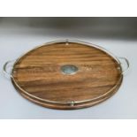 An oak two handled tray with silver plated rail handles and vacant cartouche, oval outline, 64cm
