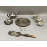 A silver plated bread board holder, teapot, dish, crumb scoop, sugar basket with swing handle and