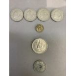 Four one dollar coins 190, an Elizabeth II five shilling coin, a three pence piece 1944 and a Edward