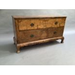 A figured walnut veneered chest of two long graduated drawers with shaped apron, angled cabriole