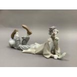 A large Lladro figure of a clown reclining, his head resting on his hand, a ball at his feet, 37cm