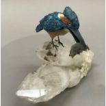 A Brazilian mineral specimen carving of a kingfisher with fish held in it's beak and perched on an