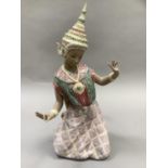 A large Lladro buff figure of a Thai dancer kneeling, 43cm high