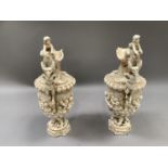 A pair of continental china ewers, the body moulded in relief with cherubs and dolphins on a mermaid