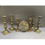 A pair of early 19th century brass candlesticks, the slender baluster columns on square stepped base