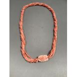 A coral necklace, the twisted multi strand necklace with a rose carved pendant front, approximate