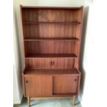 A Danish teak bookcase cupboard having three shelves above a tambour fronted compartment, and two