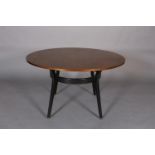 An early G Plan mahogany and ebonised circular dining table, c.1950s, the tapered legs joined by a