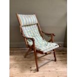 A vintage deck chair with arms, adjustable rake and striped fabric seat