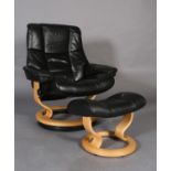 A Stressless black leather and beech reclining swivel armchair and matching footstool