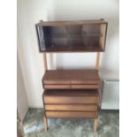 A 1960s/1970s teak modular wall unit, having a glazed two door cupboard, a set of four small drawers