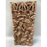 A Thai carved panel of figures amongst trees, 49cm x 23cm