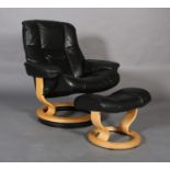 A Stressless black leather and beech reclining swivel armchair and matching footstool