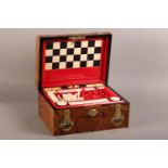 A VICTORIAN FIGURED WALNUT AND BRASS MOUNTED GAMES BOX, the lid applied with a cut brass open