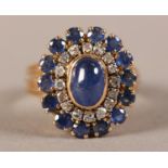 A SAPPHIRE AND DIAMOND CLUSTER RING, collet set to the centre with an oval cabochon sapphire