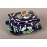 A VICTORIAN MAJOLICA DISH AND COVER with bird finial, rectangular, moulded in low relief with lily
