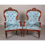 A PAIR OF VICTORIAN WALNUT ARMCHAIRS having an encircling moulded frame with carved and pierced