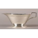 A GEORGE V OVAL SILVER SAUCE BOAT OF ART DECO STYLE on a pedestal foot by Manoah Rhodes & Sons