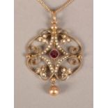 AN EDWARD VII RHODOLITE GARNET AND SEED PEARL PENDANT IN 9CT ROSE GOLD, the garnet collet set to the
