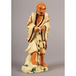 A 19TH CENTURY CHINESE EARTHENWARE FIGURE OF A MAN, standing with staff, a double gourd water