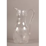 A 19TH CENTURY GLASS CLARET JUG, ovoid panel cut to the neck, over engraved waterlilies, angular
