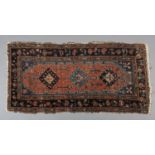 A MIDDLE EASTERN RUG OF CORAL GROUND filled with three medallions in pale and dark blue, within a