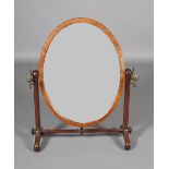A 19TH CENTURY MAHOGANY TOILET MIRROR, the oval glass within a chamfered frame, on tapered