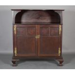 AN ARTS & CRAFTS MAHOGANY CABINET having a concave superstructure above two indented panelled