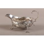 A GEORGE III SILVER CREAM BOAT London 1768 embossed with flowers, bracketed rim, leaf capped