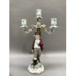 A late 19th century German porcelain three light candelabra modelled as a young male ice skater
