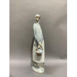 A Lladro figure of a girl carrying a basket of apples, 33cm high