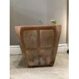 A large terracotta planter of square outline with canted corners moulded with four raised panels,