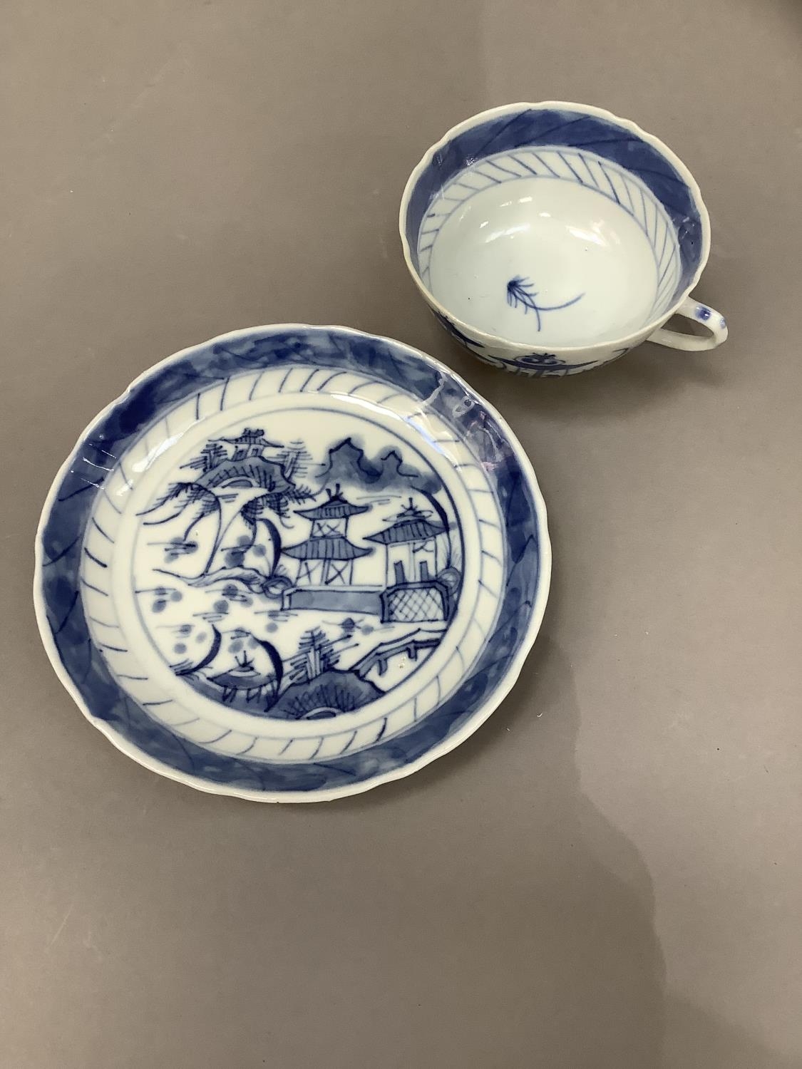 A Chinese blue and white cup and saucer painted with a pagoda and island scene