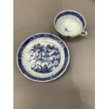 A Chinese blue and white cup and saucer painted with a pagoda and island scene
