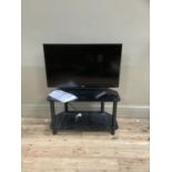 A Samsung 31" flat screen television, remote control, booklet and two tier stand