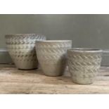 A set of three planters of moulded woven design with cream glaze, graduated sizes from 35cm diameter
