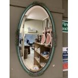 A 1930's/40's Barbola wall mirror of oval outline in pale green with bevelled glass