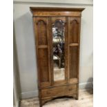 An Edwardian oak single mirror door wardrobe, drawer below, 100cm wide