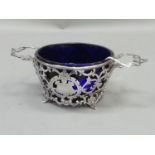 A Victorian blue glass sugar bowl within a pierced foliate scroll basket with open cartouche and