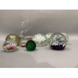 A collection of glass paperweights including examples by Caithness and a clear glass swan