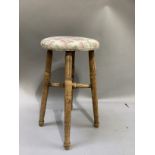 An elm stool on turned framing, circular feet with needlework cover